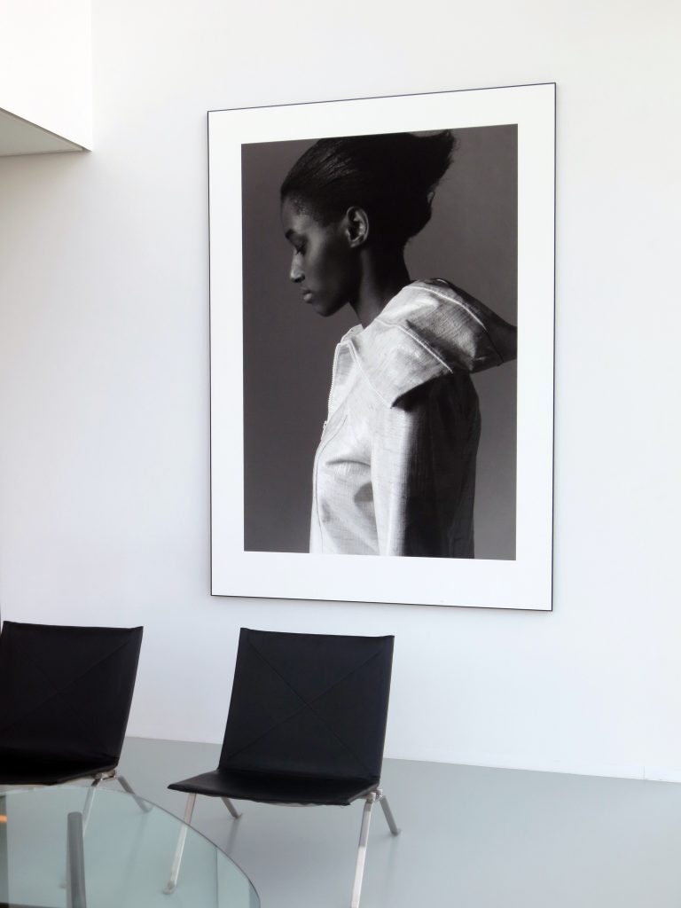 schwarz-weiss Bild einer Frau an einer weissen Wand