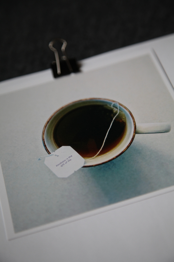 Detailaufnahme Square Print mit Tasse Tee, an weisses Blatte geheftet mit einer Klammer